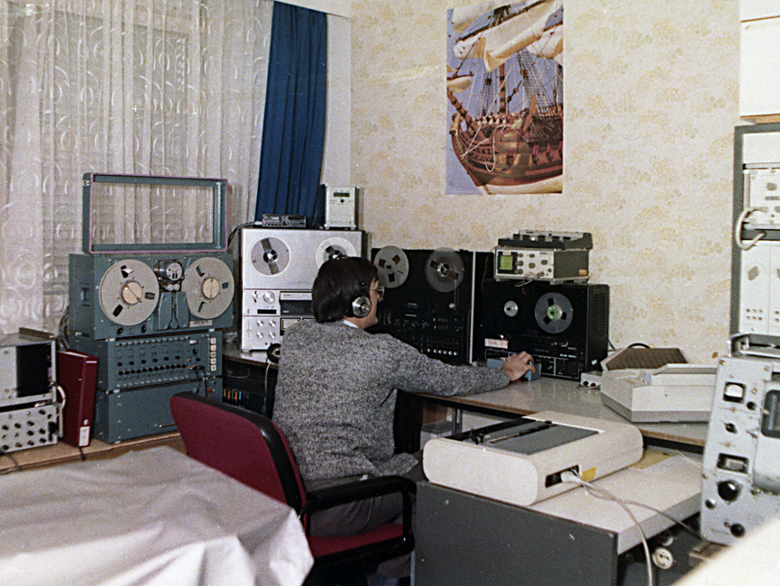 Ein Mitarbeiter der Hauptabteilung III des MfS an einem Arbeitsplatz mit Abhör- und Fernmeldetechnik.